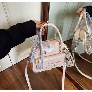 Détail du sac bowling rose avec nœud, dentelle, perles et poignée en ruban