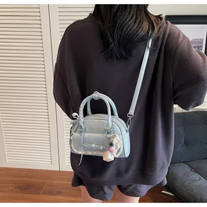 Détail du sac bleu clair avec nœud, bordure en dentelle, perles et forme bowling