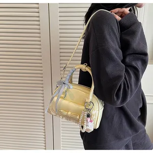 Détail du sac jaune clair avec nœud, dentelle et ruban à carreaux bleu décoratif