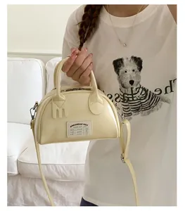 Vue détaillée du sac crème montrant l'étiquette en tissu et les détails de poignée créatifs