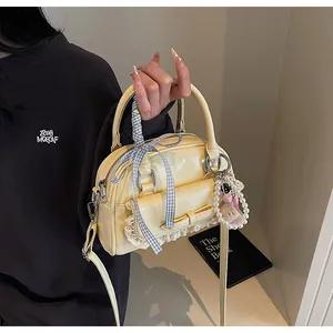 Détail d'un sac en cuir verni beige crème avec des nœuds en dentelle et des perles
