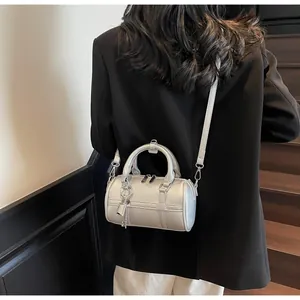 Borsa bowling argento con texture litchi e dettaglio lucchetto indossata da modella