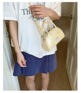 Détail d'un mini sac bowling crème en cuir PU brillant avec une boucle en métal argenté