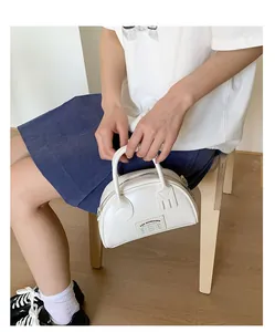 Détail du sac bowling blanc en similicuir avec décor en forme de fourchette et étiquette