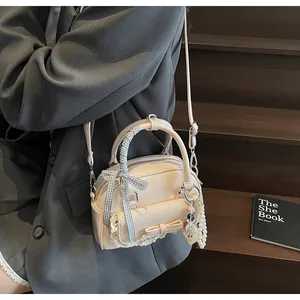 Détail d'un sac à main rose clair avec nœud, dentelle et ruban sur un modèle