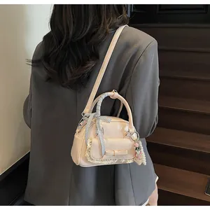 Détail du sac à main rose avec nœud et dentelle porté en bandoulière par un mannequin