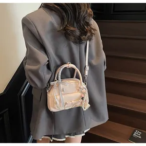 Détail du sac rose avec nœud, dentelle et perles porté par un mannequin en costume