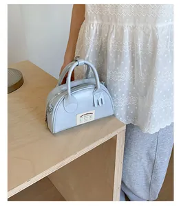 Détail du mini sac bowling bleu clair avec poignées et détails de fermeture éclair