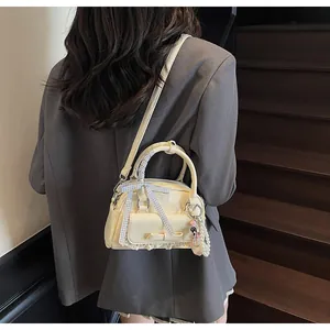 Vue arrière du mini sac bowling crème avec détails de nœuds et de dentelle
