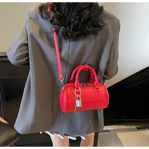 Dettaglio della borsa bowling rossa con trama a litchi e fibbia argentata sulla modella