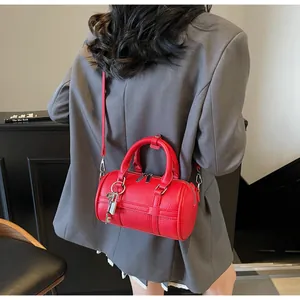 Dettaglio borsa Boston rossa in pelle a grana con lucchetto argento e tracolla sottile
