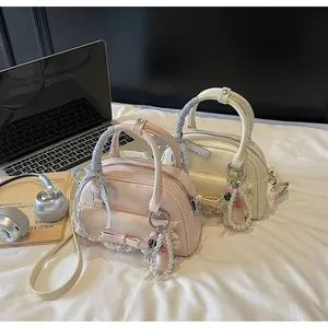Détail des sacs bowling rose et blanc crème avec nœuds, dentelle et breloques perles
