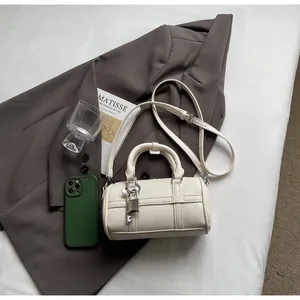 Dettaglio della mini borsa boston in pelle bianca a grana con lucchetto e chiave argento