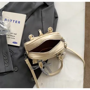 Détail du sac à main beige avec nœud à carreaux et bordure en dentelle élégante