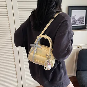 Sac bowling jaune crème avec nœud, dentelle et breloque perle porté en bandoulière