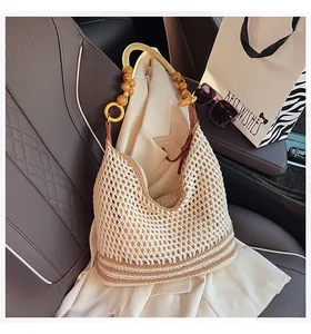Detail of bohemian knit tote bag with wooden bead handle on a car seat