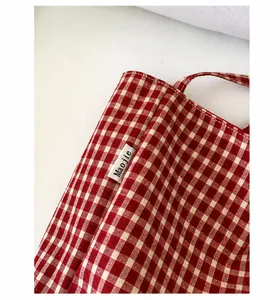 Detail shot of the red and white gingham nylon fabric with a woven Maojie brand label