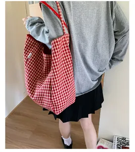 Detailed view of large red and white checkered canvas tote bag with woven side label