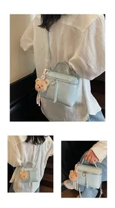 Light blue glossy box bag shown in crossbody and handheld styles with a cute bear charm