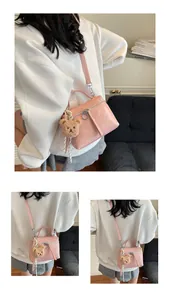 Pink textured leather handbag featuring a cute brown teddy bear charm and silver hardware