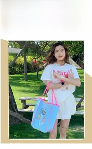 Mannequin en extérieur portant une tenue blanche et un sac cabas bleu ciel à bord rose