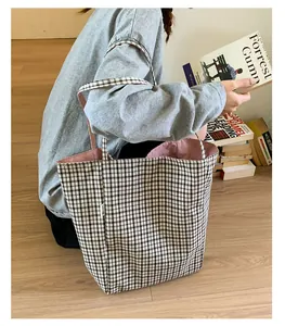 Detail of black and white checkered canvas tote bag with pink lining and soft flat handles