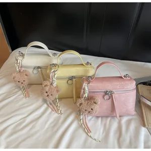 Detail of stylish textured mini tote bags with plush bear charms in various colors