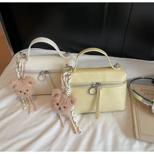 Detail of minimalist box handbags with wrinkled leather texture and cute bear charms