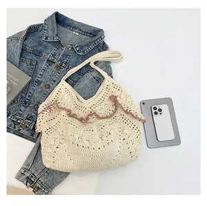 Detail van gehaakte shopper met opengewerkt weefsel, roze geschulpte rand en hengsels