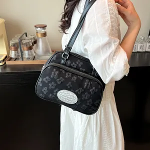 Sac bandoulière noir élégant avec texture florale en relief et large bandoulière en cuir