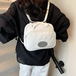 Sac à dos blanc avec broderies florales et logo métallique au design décontracté