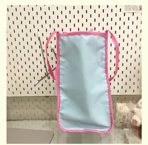 Détail du sac cabas en nylon bleu et rose montrant les poignées et les coutures