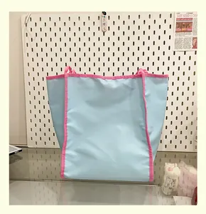 Détail du sac fourre-tout en nylon bleu clair et rose montrant la texture du tissu