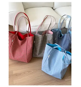 Detail view of four checkered tote bags in red, brown, and blue with durable canvas texture