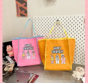 Détail de sacs fourre-tout en nylon rose et jaune avec des imprimés d'animaux mignons