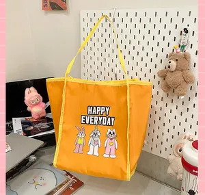 Détail d'un grand sac fourre-tout jaune vif avec des animaux mignons et texte happy