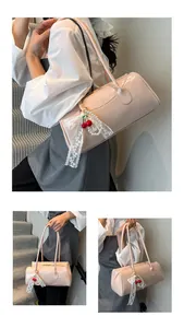 Pink faux leather underarm bag featuring decorative cherry charms and lace bow details