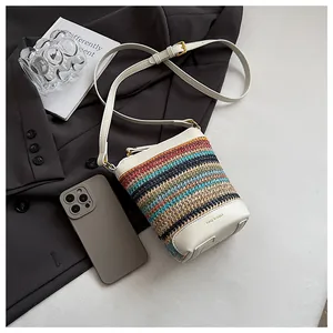 Detail of multi-color woven bucket bag with white leather base and gold Lazy Breeze logo