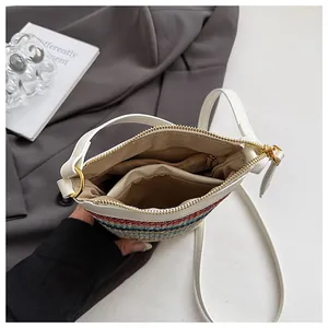 Detailed interior of a striped woven bag with white trim and a gold zipper pocket