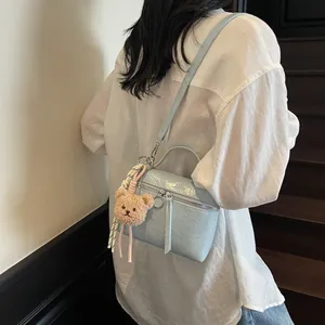 Light blue crinkled texture handbag with bear charm and adjustable shoulder strap