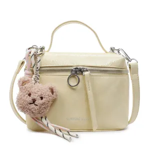 Chic beige crackle-texture handbag with plush bear charm and crossbody strap