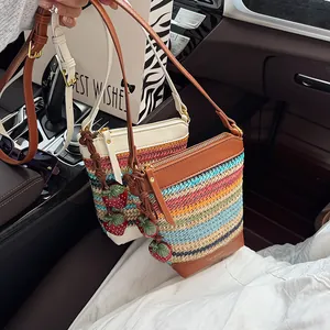 Colorful striped woven straw bucket bag with leather strap and red strawberry charm
