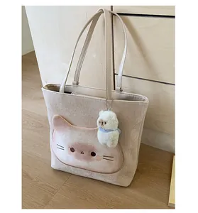 Detailansicht der beigefarbenen Cord-Tasche mit süßem Katzenmotiv und Plüsch-Anhänger