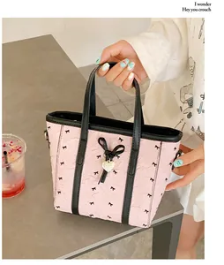 Détail du cabas rose plissé avec motifs nœuds noirs et pendentif en métal en cœur
