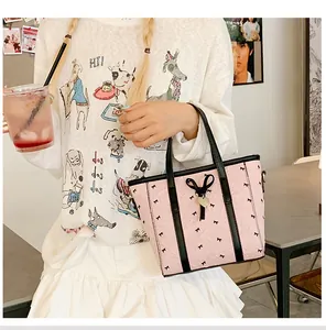 Détail du sac cabas plissé rose orné de nœuds noirs et d'un pendentif en forme de cœur