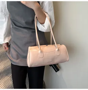 Close-up of a pink cylindrical shoulder bag with elegant slim straps and leather texture