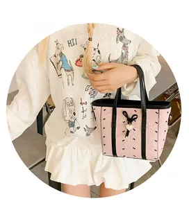 Détails du sac fourre-tout rose avec imprimés nœuds, texture froissée et pendentif cœur