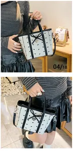 Vue détaillée d'un sac cabas blanc matelassé avec mini nœuds noirs et breloque coeur