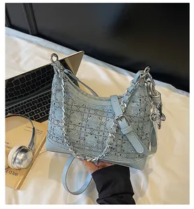 Detail of light blue denim handbag with rhinestones, metal chain and star charm
