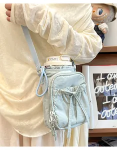Détail du sac bandoulière vert menthe pour gourde avec nœud et large bandoulière
